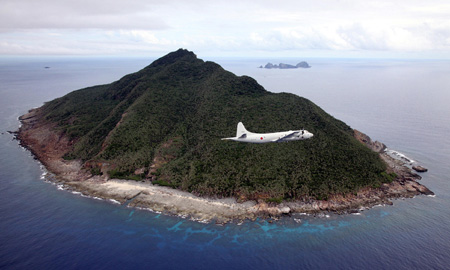 This photo taken on October 13, 2011 shows a P-3C patrol plane of Japanese Maritime Self-Defense Force flying over the disputed islets known as the Senkaku islands in Japan and Diaoyu islands in China, in the East China Sea. Japanese military and paramilitary planes have flown through China's newly declared air zone without any resistance from Chinese jets, an official and a report said on November 28, 2013. AFP PHOTO / JAPAN POOL via JIJI PRESS JAPAN OUT (Photo credit should read JAPAN POOL/AFP/Getty Images)