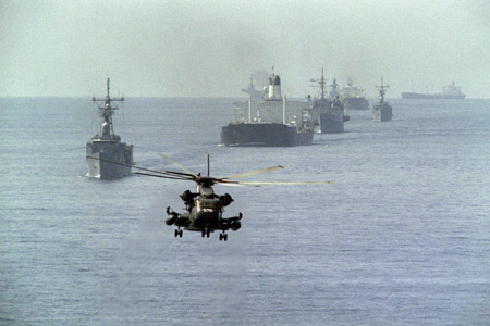 A US Navy minesweeping helicopter leads the way for the 12th US reflagged Kuwaiti tanker convoy 22 October 1987. Two tankers, Gass Prince and Ocean City, are being escorted by four US war ships (Haws, Ford, Raleigh and Standley) and the US helicopter carrier Guadacanal. The convoy is heading out of the Gulf three days after US ships bombed two Iranian oil platforms. The Tanker War started properly in 1984 when Iraq attacked Iranian tankers and the vital oil terminal at Kharg island. Iran struck back by attacking tankers carrying Iraqi oil from Kuwait and then any tanker of the Gulf states supporting Iraq. The air and small boat attacks did very little to damage the economies of either country and the price of oil was never seriously affected as Iran just moved it's shipping port to Larak Island in the straits of Hormuz. AFP PHOTO NORBERT SCHILLER (Photo credit should read NORBERT SCHILLER/AFP/Getty Images)